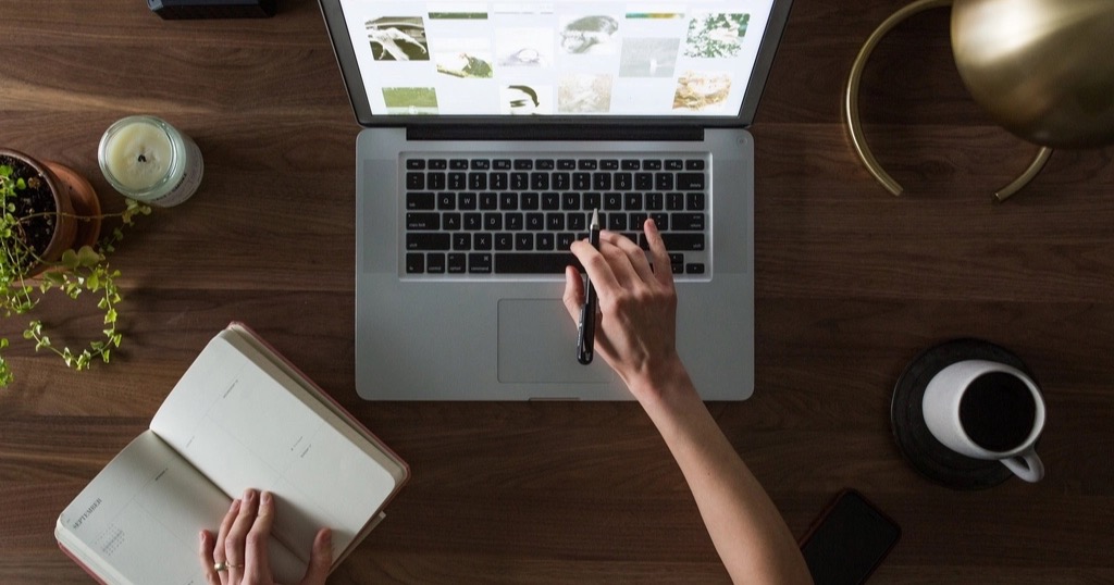 A tidy home-office desk with a laptop and coffee, where a solo founder sets up an AI assistant